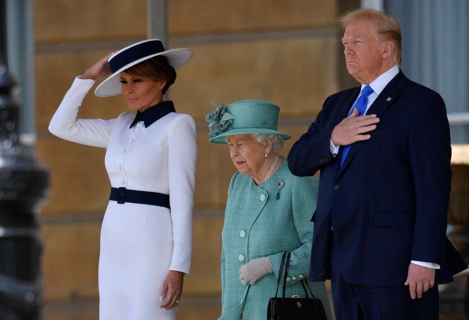 Britain's Queen Elizabeth II (C) stands with US President Donald Trump (R) and US First Lady Melania Trump (L) as they listen to the US national anthem during a welcome ceremony at Buckingham Palace in central London on June 3, 2019, on the first day of the US president and First Lady's three-day State Visit to the UK. - Britain rolled out the red carpet for US President Donald Trump on June 3 as he arrived in Britain for a state visit already overshadowed by his outspoken remarks on Brexit. (Photo by TOBY MELVILLE / POOL / AFP)        (Photo credit should read TOBY MELVILLE/AFP/Getty Images)