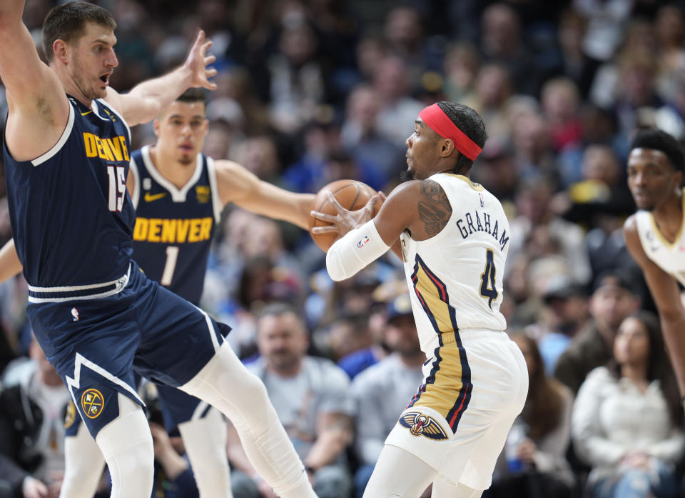 New Orleans Pelicans guard Devonte' Graham, right, looks to pass the ball as Denver Nuggets center Nikola Jokic defends in the first half of an NBA basketball game Tuesday, Jan. 31, 2023, in Denver. (AP Photo/David Zalubowski)