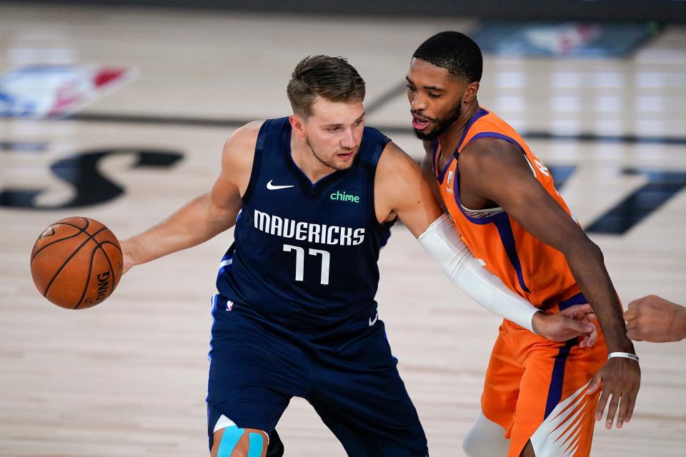 Aug 2, 2020; Lake Buena Vista, USA; Dallas Mavericks guard Luka Doncic (77) looks to drive against Phoenix Suns forward Mikal Bridges (25) during the first half of an NBA basketball game Sunday, Aug. 2, 2020, in Lake Buena Vista, Fla. Mandatory Credit: Ashley Landis/Pool Photo via USA TODAY Sports