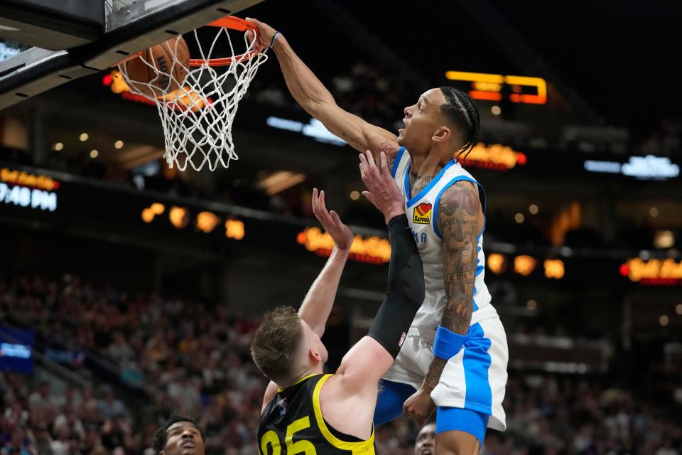 Thunder guard Tre Mann (23) dunks against Jazz center Micah Potter (25) in the first half of OKC's 95-85 win Monday in Salt Lake City.