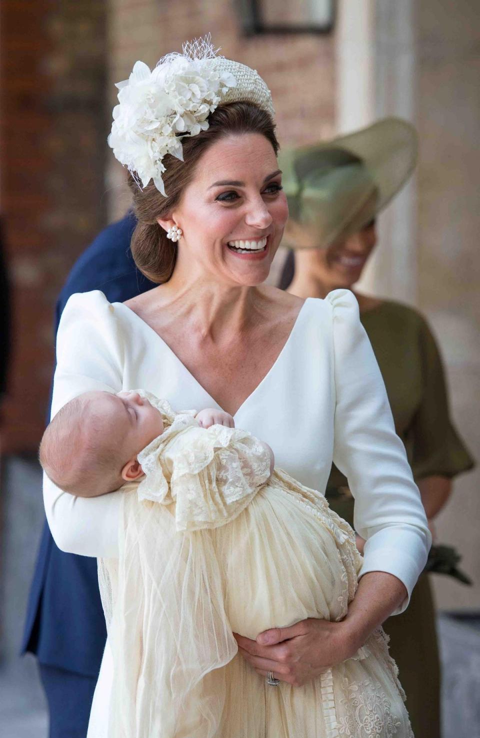 Prince Louis, 2018: On 9 July 2018, the Duchess of Cambridge was seen arriving at the Chapel Royal, St James’s Palace, London with her family carrying Prince Louis.For the occasion, the mother-of-three wore a simple white Alexander McQueen dress with puffed sleeves and a midi-length hem. She coordinated her outfits with a cream applique headband, known as the Cassandra, by milliner Jane Taylor. Prince Louis, meanwhile, was dressed in a replica of the Royal Christening Robe which was hand made by Angela Kelly, dressmaker to the Queen. On arriving at the chapel, Kate Middleton told the Archbishop of Canterbury that Prince Louis was 'very relaxed and peaceful', adding 'I hope he stays like this’. (AFP/Getty Images)