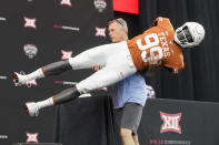 Brad Clements carries off a mannequin wearing a Texas football uniform as he dismantles the stage after the NCAA college football Big 12 media days in Arlington, Texas, Thursday, July 14, 2022. (AP Photo/LM Otero)