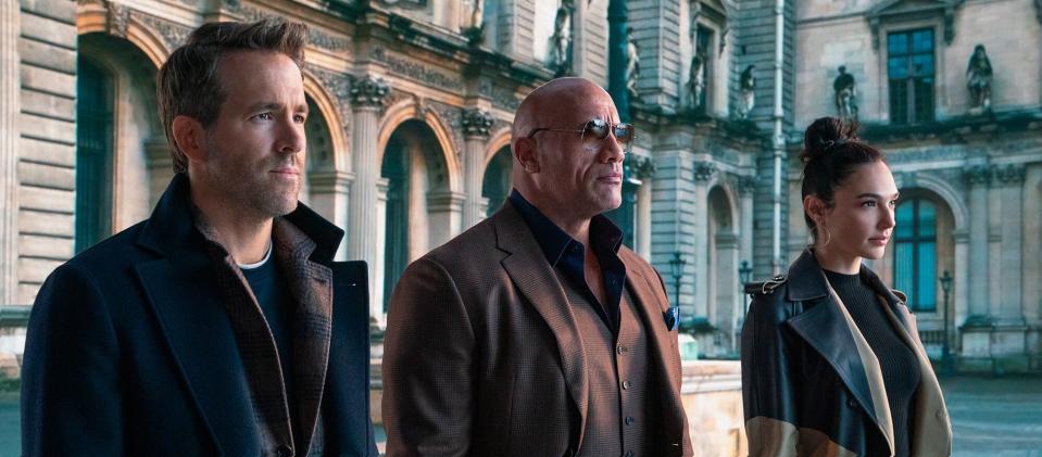 RED NOTICE - (L-R) RYAN REYNOLDS, DWAYNE ‘THE ROCK’ JOHNSON, and GAL GADOT STAR IN NETFLIX’S RED NOTICE RELEASING NOVEMBER 12, 2021. WRITTEN &amp; DIRECTED BY RAWSON MARSHALL THURBER. Cr: Frank Masi/NETFLIX © 2021