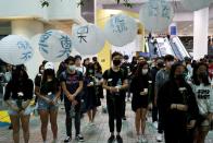 Students pay tribute with flowers to Chow Tsz-lok, 22, a university student who fell during protests at the weekend and died early on Friday morning, at the Hong Kong University of Science and Technology, in Hong Kong