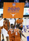 Texas guard Courtney Ramey (3) dances and holds an NCAA college basketball game championship poster for the Maui Invitational next to guard Matt Coleman III (2), Wednesday, Dec. 2, 2020, in Asheville, N.C. Texas beat North Carolina 69-67. Coleman was the MVP with the winning basket and high score of 22 points. (AP Photo/Kathy Kmonicek)