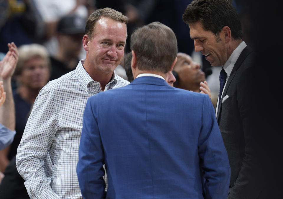 Former NFL quarterback Peyton Manning, left, chats with Joe Lacob, majority owner of the Golden State Warriors, during a timeout in the second half of Game 3 of an NBA basketball first-round Western Conference playoff series between the Warriors and the Denver Nuggets on Thursday, April 21, 2022, in Denver. (AP Photo/David Zalubowski)