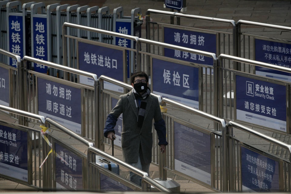 A passenger wearing a protective face mask enters a subway station at the railway station as they arrive in Beijing, Tuesday, Feb. 11, 2020. China's daily death toll from a new virus topped 100 for the first time and pushed the total past 1,000 dead, authorities said Tuesday after leader Xi Jinping visited a health center to rally public morale amid little sign the contagion is abating. (AP Photo/Andy Wong)