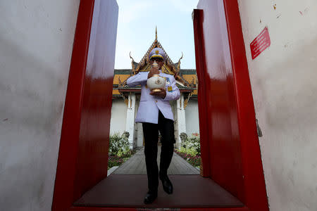 FILE PHOTO: A royal official holds an ewer containing sacred water collected from all provinces in Thailand, during a procession to deliver it from Wat Suthat to the Grand Palace, to be consecrated for the upcoming coronation ceremony for Thailand's King Maha Vajiralongkorn in Bangkok, Thailand, April 19, 2019. REUTERS/Athit Perawongmetha/File Photo