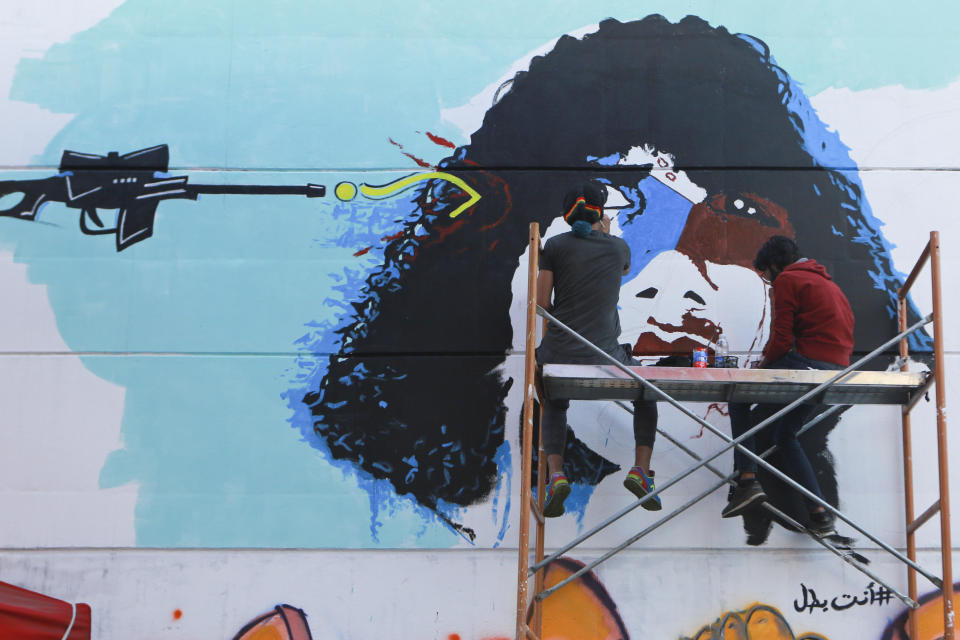 In this Sunday, Nov. 17, 2019 photo, Iraqi artists draw graffiti at the Saadoun Tunnel, in Baghdad, Iraq. The tunnel that passes under Baghdad’s landmark Tahrir Square has become an ad hoc museum for Iraq's revolution: Young artists draw images and murals that illustrate the country’s tortured past, and the Iraq they aspire to. (AP Photo/Hadi Mizban)