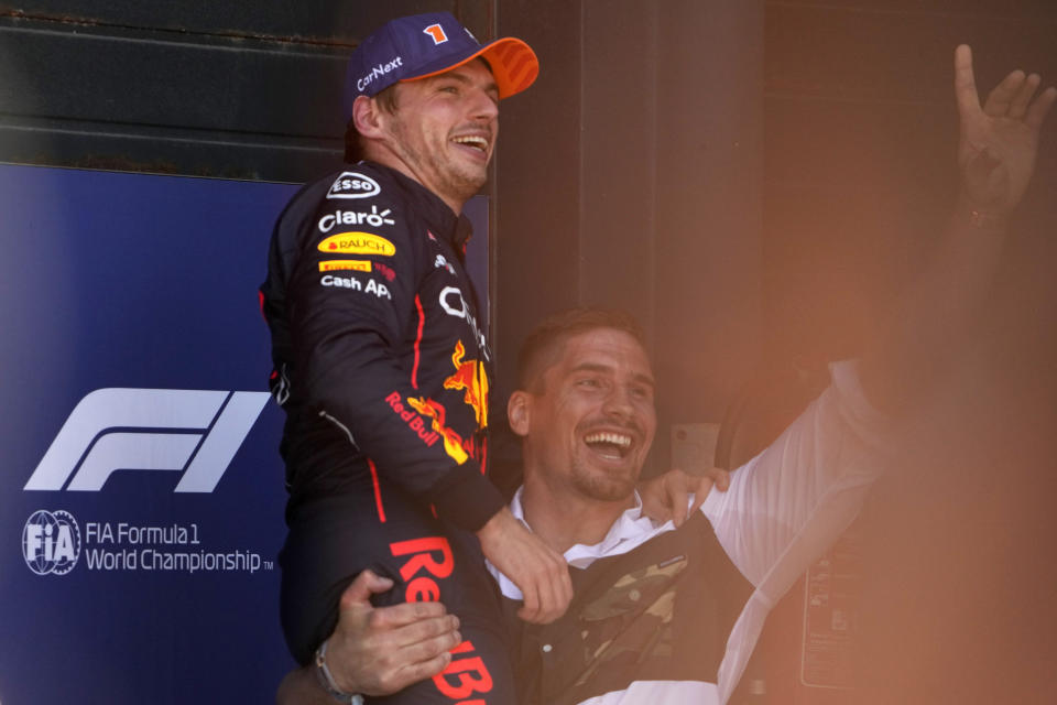 Dutch professional kickboxer Rico Verhoeven lifts his friend Red Bull driver Max Verstappen of the Netherlands for the fans after he clocked the fastest time in the qualifying session ahead of Sunday's Formula One Dutch Grand Prix auto race, at the Zandvoort racetrack, in Zandvoort, Netherlands, Saturday, Sept. 3, 2022. (AP Photo/Peter Dejong)