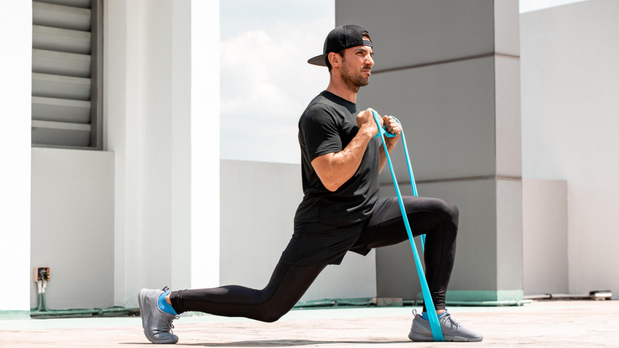  Man doing banded lunges. 