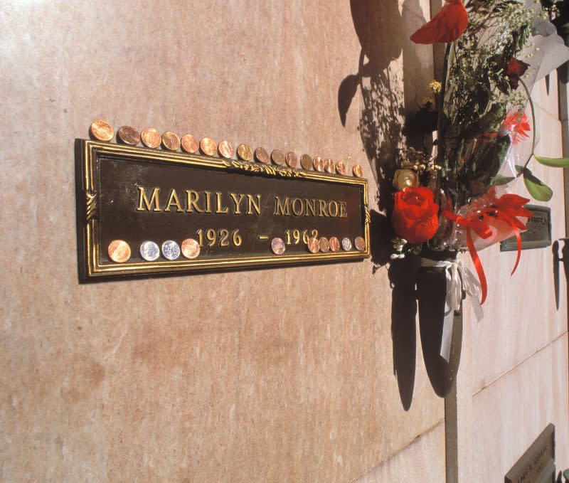 Plaque for Marilyn Monroe's grave inside a crypt with pennies laid on top of it