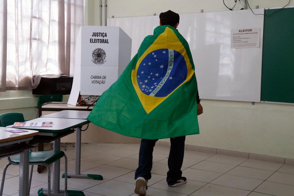 Un hombre ennvuelto con la bandera de Brasil. (Photo by Miguel Schincariol / AFP) (Photo by MIGUEL SCHINCARIOL/AFP via Getty Images)