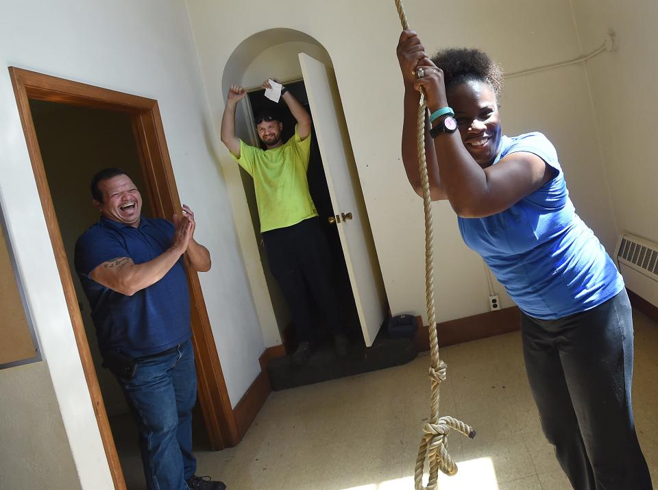 Pastor Heather Boone of Oaks of Righteousness Christian Church, ringing the church bell, was all smiles after receiving the keys to the former St. Joseph Catholic Church Aug. 22, 2016,
from her real estate agent Joel Garcia of Key Realty in Monroe, left. Behind, celebrating, is Boone's husband, Britton Boone. Many volunteers came to help Boone to start cleaning the buildings of the new Oaks Victory Village and working on the landscaping.
