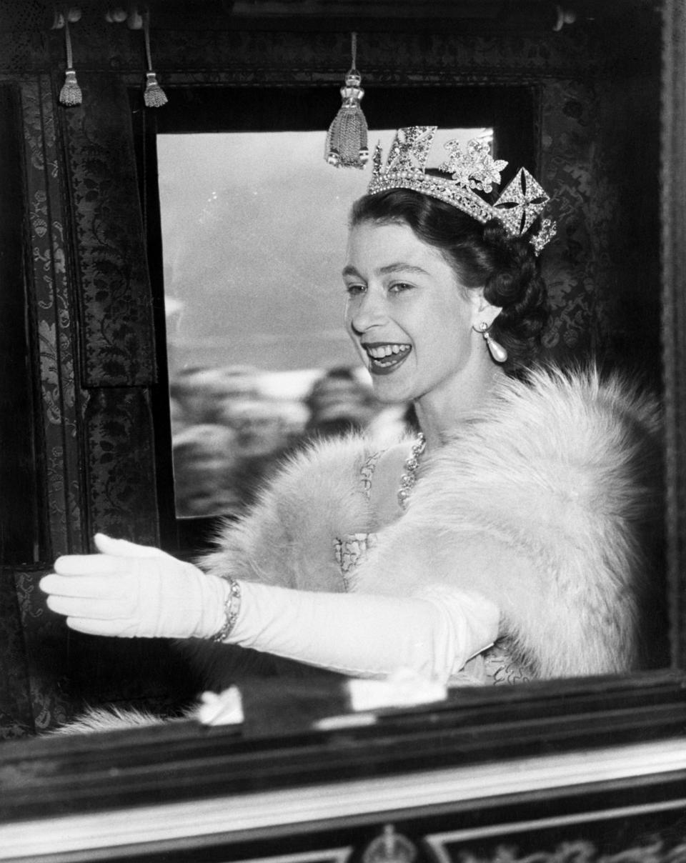(Original Caption) 11/5/1952-London, England: Queen Elizabeth II, 26 years young, is radiantly happy here as she waves and smiles in acknowledgement of the cheers of the crowd as she drove in the state coach to the House of Lords yesterday. History was made as the young queen appeared in the House of Lords to open the First Parliament of her reign. Her address, prepared by the government, indicated that Britain will swing back to Capitalism in 1953 by denationalizing the steel and trucking industries.