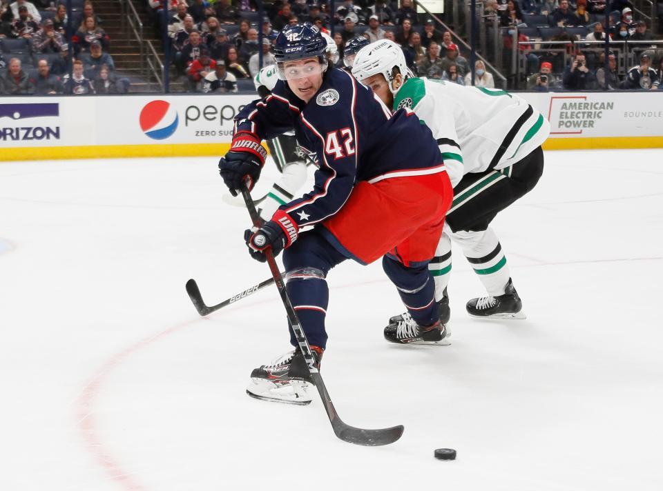 Columbus Blue Jackets center Alexandre Texier (42) drops a pass back behind Dallas Stars defenseman Jani Hakanpaa (2) during the first period of the NHL hockey game at Nationwide Arena in Columbus on Monday, Oct. 25, 2021. 