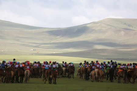 Child jockeys riding horses head to the start line for the Soyolon horse race at the Mongolian traditional Naadam festival, on the outskirts of Ulaanbaatar, Mongolia July 12, 2018. Picture taken July 12, 2018. REUTERS/B. Rentsendorj