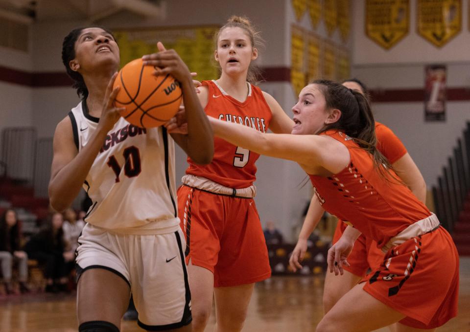 Jackson senior Amber Williams shoots as Cherokee senior Katie Fricker closes in