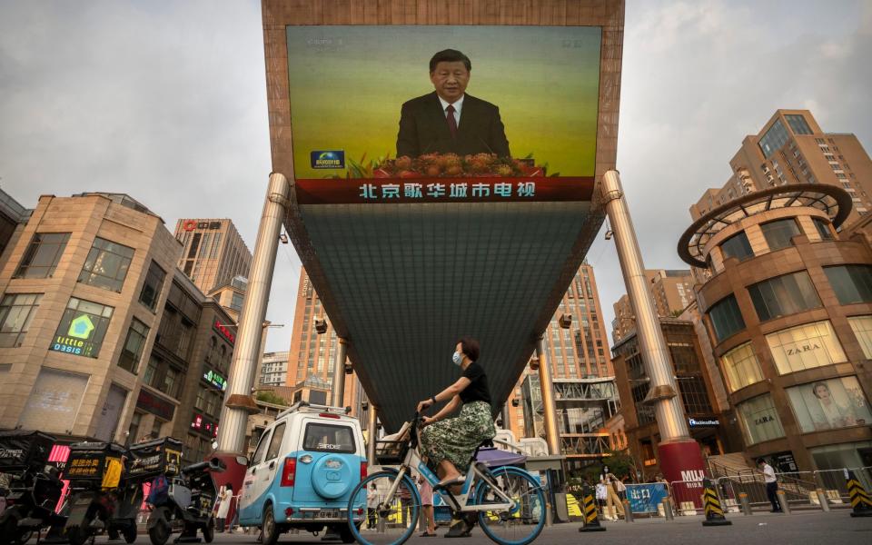 Mr Xi's speech is beamed to residents via a giant television screen - AP