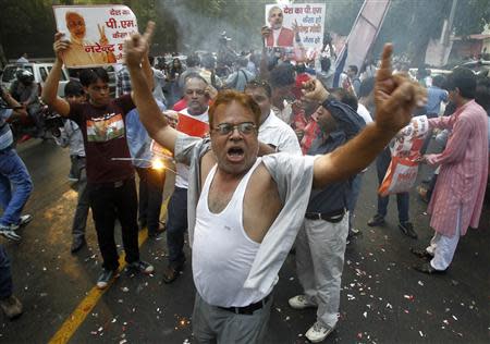 Supporters of India's main opposition Bharatiya Janata Party (BJP) dance in celebration before India's Hindu nationalist Narendra Modi was crowned as the prime ministerial candidate for the party outside its party headquarters in New Delhi September 13, 2013. REUTERS/Anindito Mukherjee