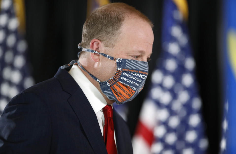 Colorado Governor Jared Polis wears a face mask as he turns to leave after a news conference to update the state's efforts to check the spread of the new coronavirus Monday, May 11, 2020, in Denver. (AP Photo/David Zalubowski)