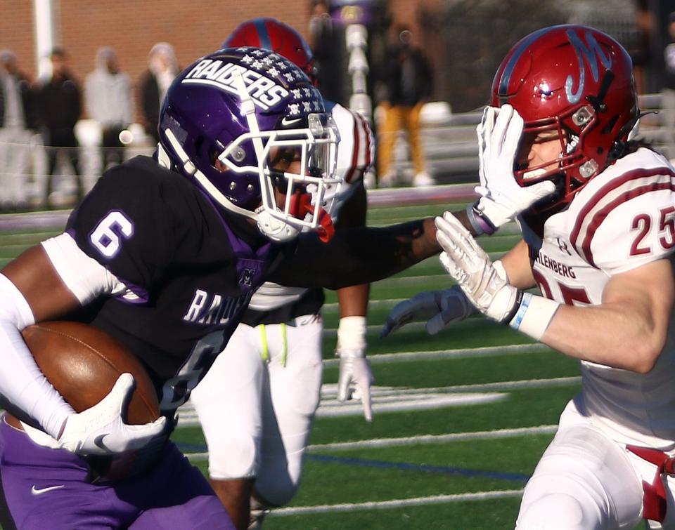 Mount Union receiver Wayne Ruby, Jr, left, stiff arms Muhlenberg defender John Lohrer during their quarterfinal playoff game against Muhlenberg, Saturday, December 4, 2021