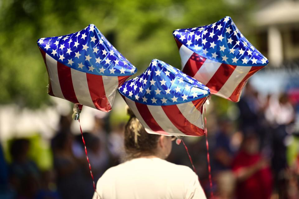 American flag balloons are held by a participant during the Memorial Day Parade in Oakland, Bergen County, on Sunday, May 29.