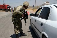 A Turkish soldier checks cars at a checkpoint in Diyarbakir in the Kurdish-dominated southeast of the country on July 26, 2015