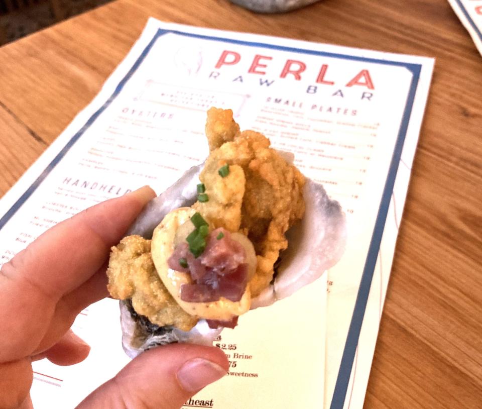 The Crispy oyster on the menu at Perla Raw Bar, at 1039 Ashes Dr., Wilmington comes with country ham butter, pickled celery and creole aioli.
