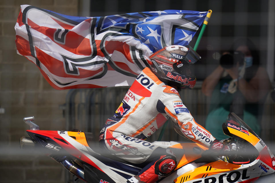 Spain's Marc Marquez carries a flag as he celebrates his win at the MotoGP Grand Prix of the Americas motorcycle race at Circuit of the Americas, Sunday, Oct. 3, 2021, in Austin, Texas. (AP Photo/Eric Gay)