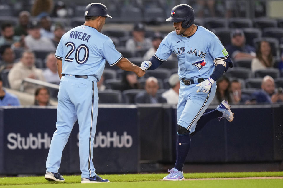 Toronto Blue Jays George Springer (4) celebrates with third base coach Luis Rivera (20) after hitting a homerun during the first inning of a baseball game against the New York Yankees, Tuesday, Sept. 19, 2023, in New York. (AP Photo/Bryan Woolston)