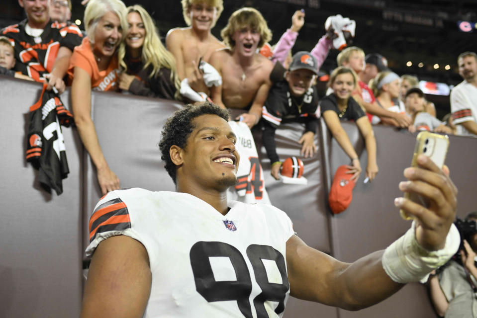 Cleveland Browns defensive end Isaac Rochell (98) takes a selfie for fans after an NFL preseason football game against the Chicago Bears, Saturday, Aug. 27, 2022, in Cleveland. The Bears won 21-20. (AP Photo/David Richard)