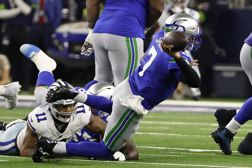 Seattle Seahawks quarterback Geno Smith (7) attempts to throw a pass after being pressured by Dallas Cowboys linebacker Micah Parsons (11) in the first half of an NFL football game in Arlington, Texas, Thursday, Nov. 30, 2023. (AP Photo/Roger Steinman)