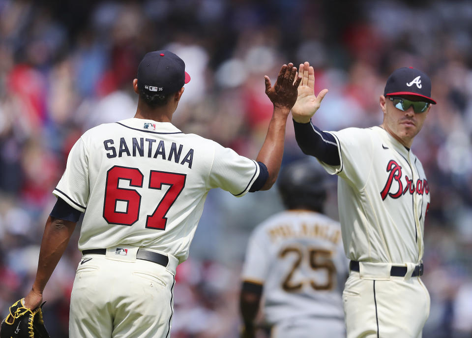 Atlanta Braves first baseman Freddie Freeman gives pitcher Edgar Santana a high-five after Santana closed out the Pittsburgh Pirates during the ninth inning for a victory in a baseball game Sunday, May 23, 2021, in Atlanta. (Curtis Compton/Atlanta Journal-Constitution via AP)