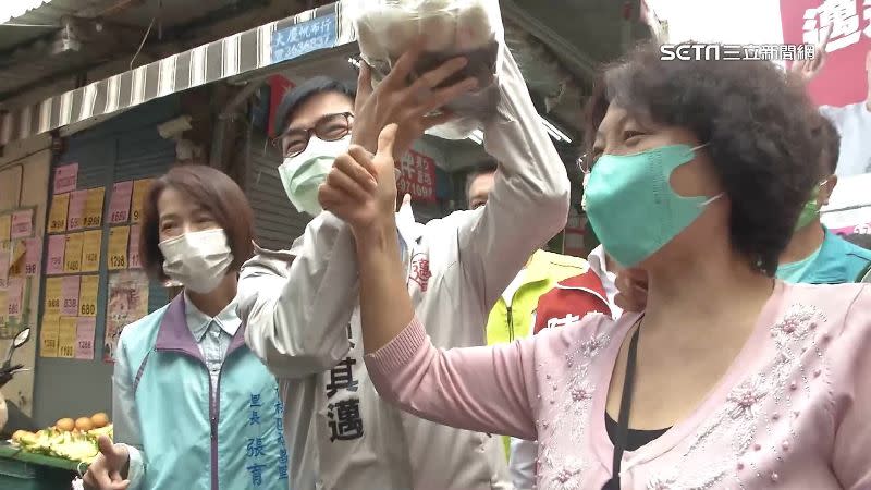 民進黨高雄市長候選人陳其邁笑瞇眼開心收下熱情攤商送來的包粽。