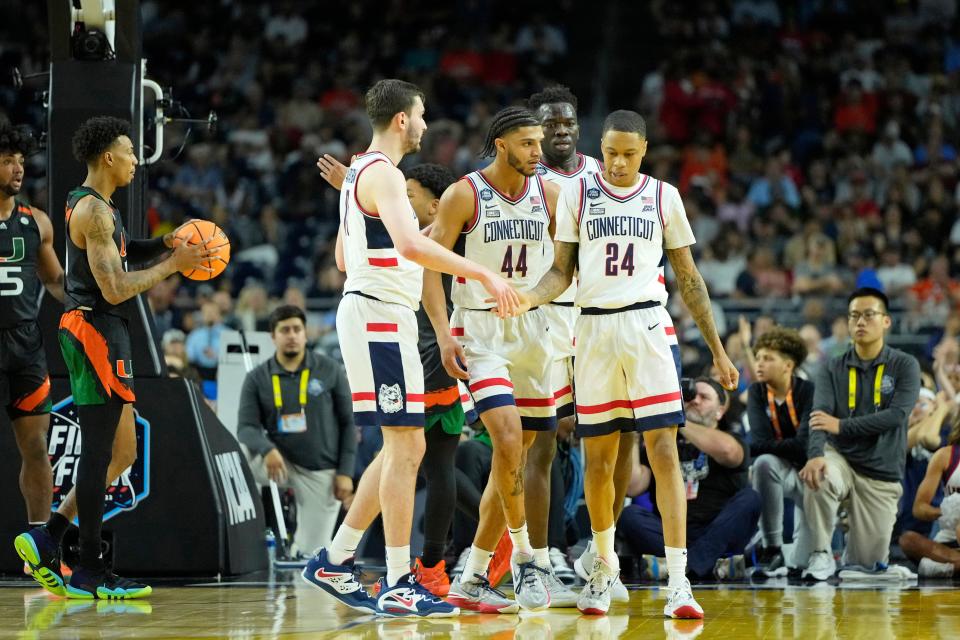 Connecticut guard Jordan Hawkins (24) shakes hands with a teammate after a play against Miami in the national semifinals of the 2023 NCAA men's tournament at NRG Stadium in Houston.