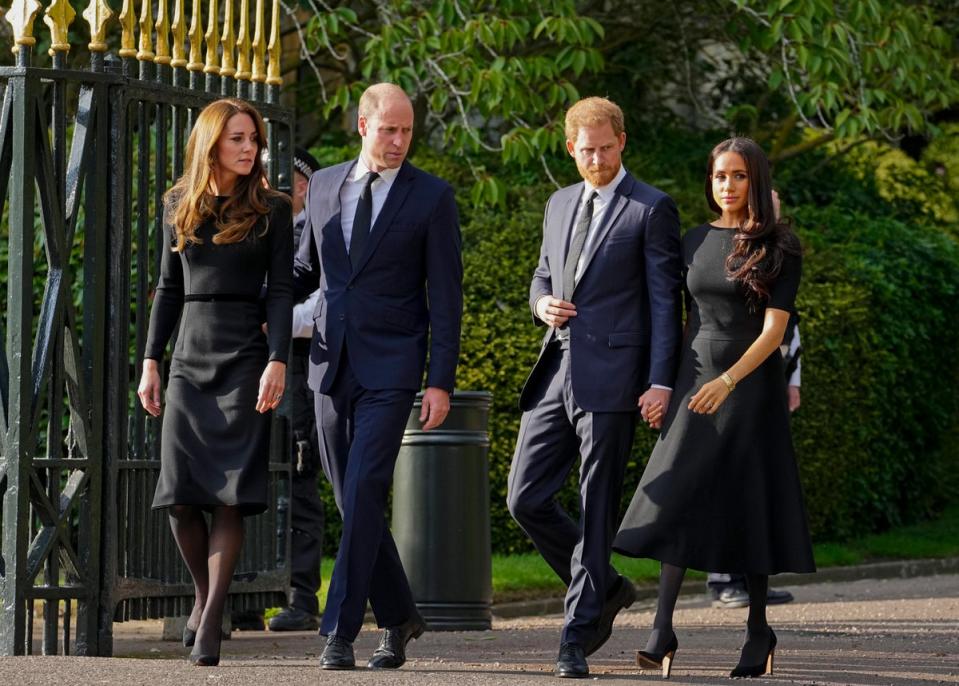 Prince William, second left, Kate, Princess of Wales, left, Prince Harry, second right, and Meghan, Duchess of Sussex view floral tributes to Queen Elizabeth II (AP)