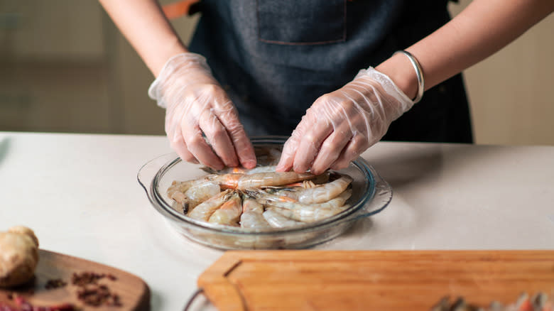 chef handling shrimp with gloves