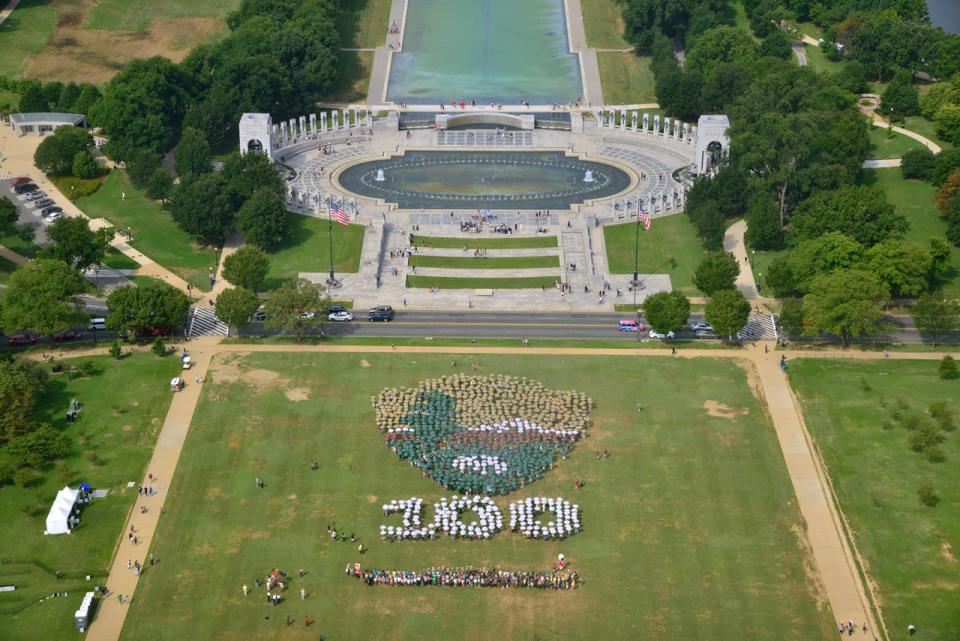 <p>This photo provided by the National Park Service shows people on the National Mall in Washington, looking toward the World War II Memorial, Aug. 25, 2016, creating a giant, living version of the National Park Service emblem. Participants used brown, green and white umbrellas to create the emblem. (Photo: Tim Ervin/National Park Service/AP)</p>