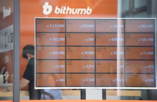 A man stands behind a screen showing exchange rates of cryptocurrencies at Bithumb virtual currency exchange in Seoul on June 20, 2018; Facebook's new Libra digital money is being backed by cash in an effort to maintain a stable value