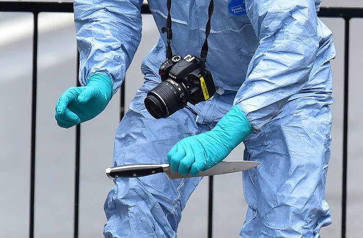 A police forensic officer holds a knife Thursday after a man was arrested following an incident at Whitehall in London, April 27, 2017. (Dominic Lipinski/PA via AP)