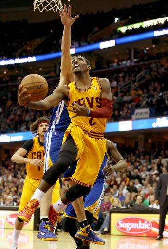 Kyrie Irving #2, de los Cleveland Cavaliers, intenta lanzar a la cesta marcado por David Lee #10, de los Golden State Warriors, en partido de la liga NBA jugado en el Quicken Loans Arena, el 29 de diciembre de 2013, en Ohio. (GETTY IMAGES NORTH AMERICA/AFP | Mike Lawrie)