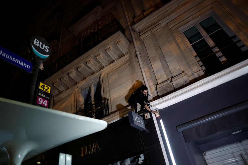 Un activista del equipo de parkour "On the Spot" sube a un edificio en una noche en la que se apagan las luces de decenas de escaparates para concienciar sobre el ahorro de energía y la reducción de la contaminación lumínica en París