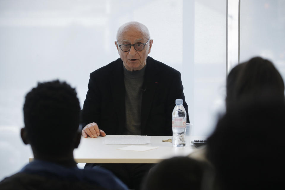 In this photo taken on Thursday Jan. 30, 2020, Victor Perahia, interned as a child in the Drancy camp and deported to Bergen-Belsen speaks to students during a workshop dedicated to the Holocaust remembrance at the Drancy Shoah memorial, outside Paris. French Holocaust survivor Victor Perahia was 9 when his family was seized by the Nazis, but couldn't bear to speak about what happened for 40-years, but is now telling his story to schoolchildren at Drancy, backdropped by the buildings that once imprisoned him. (AP Photo/Christophe Ena)