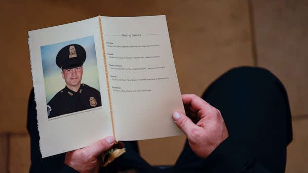 PHOTO: In this Feb. 3, 2021, file photo, a Capitol Police Officer holds a program for a ceremony in honor of Capitol Police officer Brian Sicknick in the Rotunda of the U.S. Capitol in Washington, D.C. (Demetrius Freeman, POOL/AFP via Getty Images, FILE)