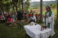 Friar Leopoldo Serrano celebrates an outdoor Mass at Mission San Francisco de Asis, in Honduras, Sunday, June 27, 2021. The pastor of souls has turned into a project manager and construction foreman for the families of La Reina, a nearby Honduran village buried in an epic mudslide in November 2020, its families among nearly half a million Central Americans displaced by Hurricanes Eta and Iota. (AP Photo/Rodrigo Abd)