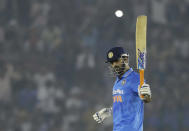 FILE - In thos Sunday, Oct. 23, 2016, file photo, Indian cricket captain Mahendra Singh Dhoni raises his bat after scoring half a century during the third one-day international cricket match against New Zealand in Mohali, India. India great Dhoni announced his retirement from international cricket on Saturday, Aug. 15, 2020. Under Dhoni’s stewardship, India won the T20 World Cup in 2007, the 50-over World Cup in 2011 and the Champions Trophy in 2013. (AP Photo/Tsering Topgyal, File)