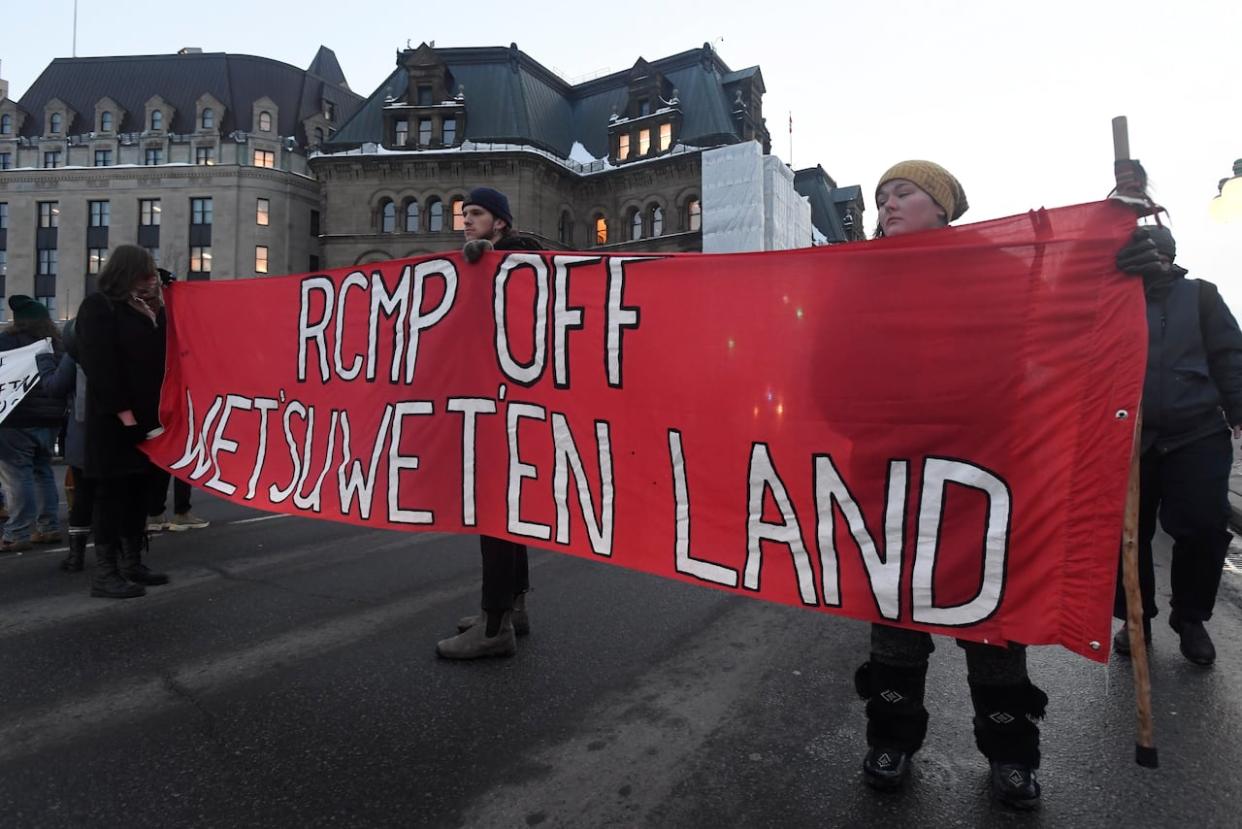 Protesters in solidarity with the Wet'suwet'en hereditary chiefs opposed to an LNG pipeline in northern British Columbia block an Ottawa intersection outside the prime minister's office Feb. 12, 2020. (Adrian Wyld/The Canadian Press - image credit)