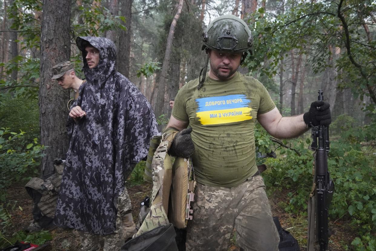 Ukrainian servicemen take their position near the frontline in Kharkiv region, Ukraine, Tuesday, July, 5, 2022. The writing on the T-shirt reads "Good evening. We are from Ukraine". (AP Photo/Andrii Marienko)