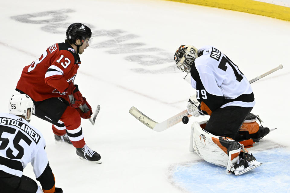 Philadelphia Flyers goaltender Carter Hart (79) makes a stop on a shot by New Jersey Devils center Nico Hischier (13) during the third period of an NHL hockey game Thursday, Dec. 15, 2022, in Newark, N.J. The Flyers defeated the Devils 2-1. (AP Photo/Bill Kostroun)